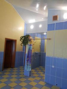 La salle de bains est pourvue d'une douche et de murs en carrelage bleu. dans l'établissement Дом для Души с бассейном целиком, à Vinnytsia