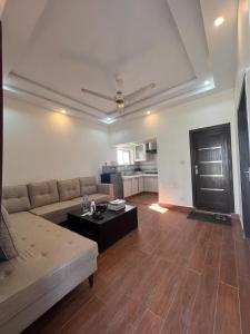 sala de estar con sofá y mesa en Haven Lodge, Family Suite with Lounge & Kitchen, en Islamabad