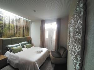 ein Hotelzimmer mit einem Bett und einem Stuhl in der Unterkunft CASA DE PERAIS in Perais