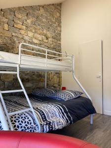 a bunk bed in a room with a stone wall at La Chambre du Tonneau in Montigny-sur-lʼAin