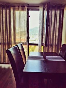 a table and chairs in a room with a large window at Nice & economic Studio in Baia Mare