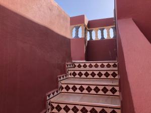 a staircase in a building with a red wall at Ocean Desert Spirit in Akhfennirr