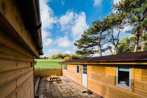 un edificio de madera con una mesa de picnic al lado en Low Moor Lodge, en Scarborough