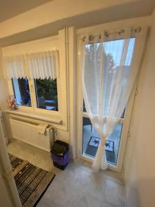 ピエシュチャニにあるUbytovanie Danaの白いカーテン付きの窓のある部屋