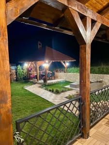 a backyard with a wooden pergola at night at TOP3 in Predeluţ
