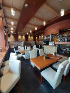 コパオニクにあるApart Hotel & Spa Zoned II, apartman Bebi, br 1411の白い椅子とテーブル、カウンター付きのレストラン