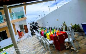 una mesa con mesas de colores vivos y sillas con velas en Aconchegante casa de praia em Paripueira/AL, en Paripueira