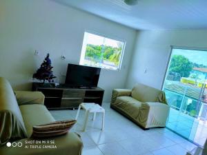 una sala de estar con 2 sofás y un árbol de Navidad en Aconchegante casa de praia em Paripueira/AL, en Paripueira