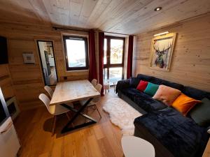 salon z kanapą i stołem w obiekcie Les appartements Makalu Val Thorens w Val Thorens