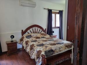 1 dormitorio con cama con edredón y ventana en Hostal las Rosas en Salta