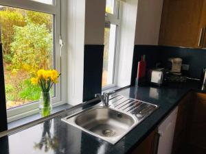 a kitchen counter with a sink and a window at Cosy 3 bedroom home in centre of Brodick in Brodick