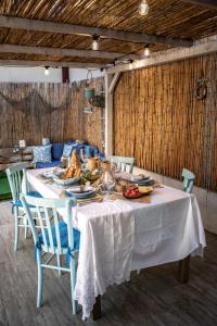 uma mesa de jantar com uma toalha de mesa branca e cadeiras em Casa Cristina em Porto Pino