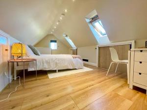 a bedroom with a bed and a table and a chair at The Little Gable in Wavendon