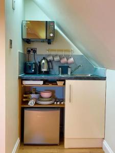a small kitchen with a counter with a microwave at The Little Gable in Wavendon