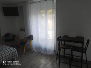 a room with a table and chairs and a window at Joli studio au centre d'Uriage in Vaulnaveys-le-Haut