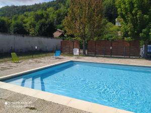 a blue swimming pool with two chairs and a fence at Joli studio au centre d'Uriage in Vaulnaveys-le-Haut +7 photos