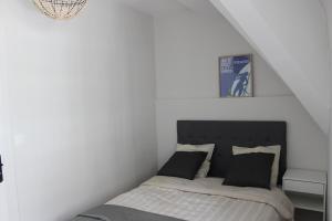 ein Schlafzimmer mit einem Bett in einem weißen Zimmer in der Unterkunft Intra-Muros - T2 La Grande Hermine in Saint-Malo