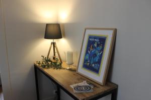 einen Tisch mit einer Lampe und einem Bild darauf in der Unterkunft Intra-Muros - T2 La Grande Hermine in Saint-Malo