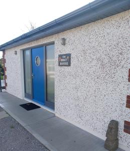 un edificio con una puerta azul y un cartel en él en The Boathouse, en Cork