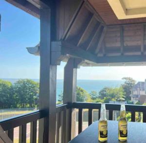 - deux bouteilles de bière assises sur une table sur une terrasse couverte dans l'établissement Appart lumineux avec vue sur mer à 180 degrés, à Trouville-sur-Mer