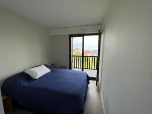 - une chambre avec un lit bleu et un balcon dans l'établissement Appart lumineux avec vue sur mer à 180 degrés, à Trouville-sur-Mer