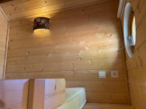 a small room with a bed in a wooden wall at Le Paradis de Verdure in Natzwiller