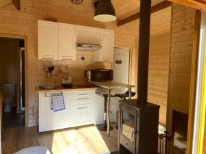 uma cozinha com armários brancos e um fogão em Le Paradis de Verdure em Natzwiller