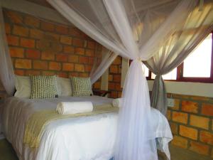 a bedroom with a bed in a brick wall at Moz T's Lodge in Inhambane
