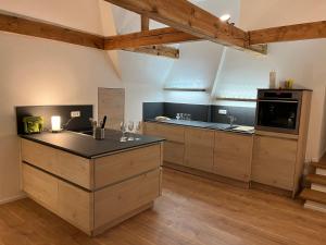 a kitchen with wooden cabinets and a black counter top at Super Lodge Kulmbach in Kulmbach