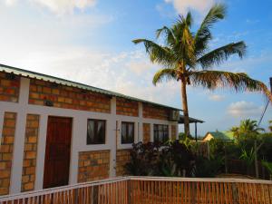 a house with a palm tree in front of it at Moz T's Lodge in Inhambane