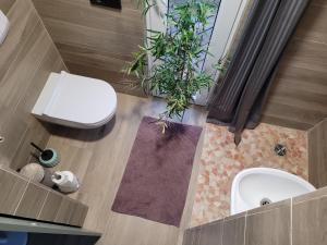a bathroom with a white toilet and a sink at Vaitų Riešutynė - Small shipping container house 