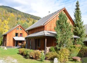 ein großes Holzhaus mit einem Berg im Hintergrund in der Unterkunft Ferienhaus Kreischberg in Sankt Lorenzen ob Murau
