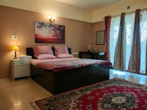 um quarto com uma cama grande e almofadas cor-de-rosa em Portofino em Lavasa