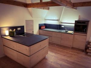 uma grande cozinha com armários de madeira e um balcão preto em Super Lodge Kulmbach em Kulmbach