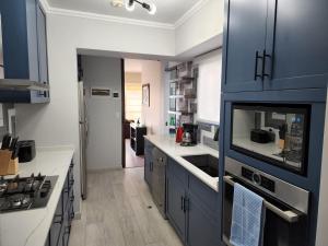 uma cozinha com armários azuis e bancadas brancas em 4BR Quiet Apartment Miraflores Larcomar em Lima