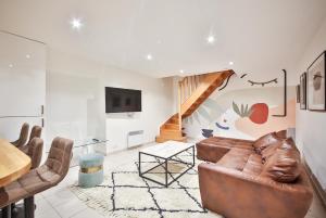salon ze skórzaną kanapą i schodami w obiekcie 02#Duplex 2Bedrooms#Sèvres Lecourbe#Necker w Paryżu