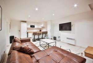 salon z brązową skórzaną kanapą w obiekcie 02#Duplex 2Bedrooms#Sèvres Lecourbe#Necker w Paryżu