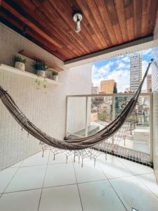 a hammock in a room with a view of a city at Apto conforto extremo no melhor do Centro de CWB in Curitiba
