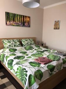 a bedroom with a bed with a green and white comforter at Panoráma Apartman Felsötárkány in Felsőtárkány