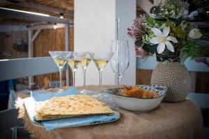 una mesa con copas de vino y un plato de comida en Casa Cristina, en Porto Pino