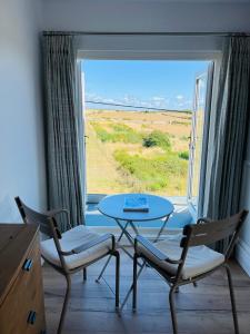 a room with a table and two chairs and a window at Woodlands in Southerndown