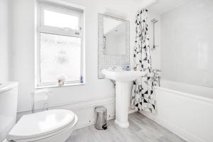 a white bathroom with a sink and a toilet at Spacious Home - Ideal for Contractors in Northampton