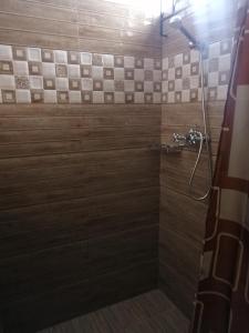 a bathroom with a shower with wooden tiles at Hortensia in Quatre Bornes