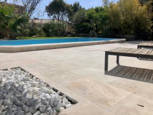 une terrasse avec une table de pique-nique et une piscine dans l'établissement L'arbousier, à Cassis