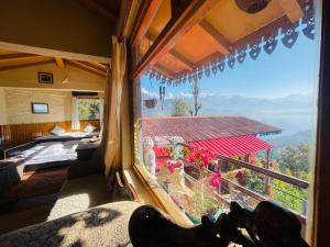 MunsyariにあるNeer Staysの山々の景色を望む大きな窓が備わる客室です。