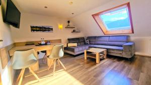 ein Wohnzimmer mit einem Sofa und einem Tisch in der Unterkunft Ferienwohnungen Wolf - Pfronten Mitte, in Pfronten
