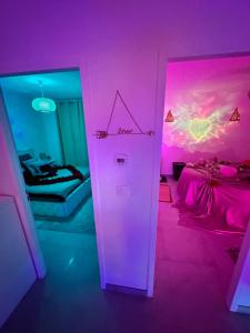 um quarto com um quarto rosa com uma cama e uma porta em Jacuzzi Appartement love room em Freneuse