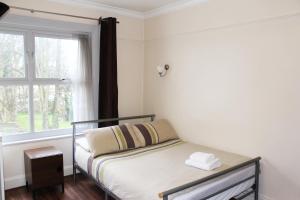 a bed in a room with a window at Flexistay Norbury Aparthotel in London