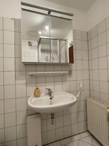 a white bathroom with a sink and a mirror at Ferienwohnung Bördeblick in Barby