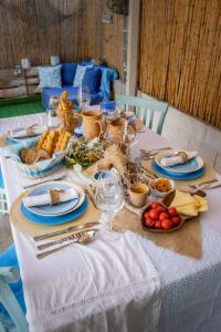 una mesa con un mantel blanco con comida. en Casa Cristina, en Porto Pino